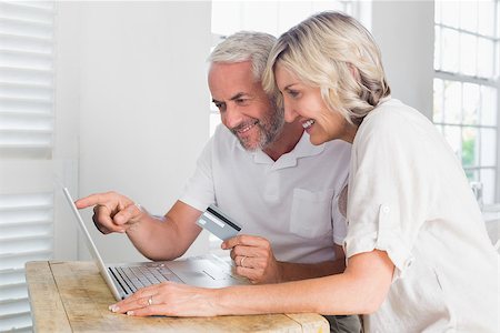 simsearch:400-07333971,k - Happy mature couple doing online shopping through laptop and credit card at home Stock Photo - Budget Royalty-Free & Subscription, Code: 400-07344062