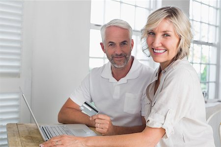 simsearch:400-07333971,k - Happy mature couple doing online shopping through laptop and credit card at home Stock Photo - Budget Royalty-Free & Subscription, Code: 400-07344070