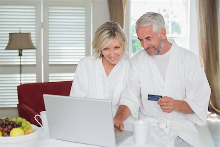 simsearch:400-07333971,k - Happy mature couple doing online shopping through laptop and credit card at home Stock Photo - Budget Royalty-Free & Subscription, Code: 400-07344154