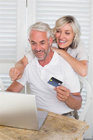 simsearch:400-07333971,k - Happy mature couple doing online shopping through laptop and credit card at home Stock Photo - Budget Royalty-Free & Subscription, Code: 400-07344150