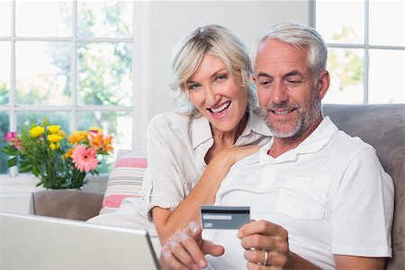 simsearch:400-07333971,k - Happy mature couple doing online shopping through laptop and credit card at home Stock Photo - Budget Royalty-Free & Subscription, Code: 400-07344203