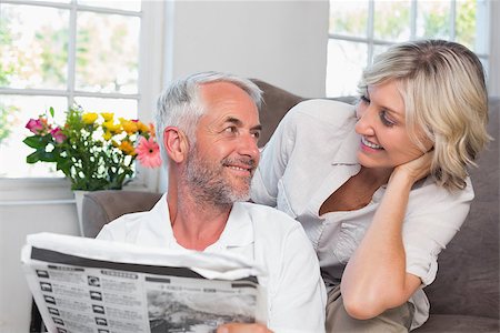 simsearch:400-07333928,k - Happy mature couple looking at each other while reading newspaper at home Stock Photo - Budget Royalty-Free & Subscription, Code: 400-07344371