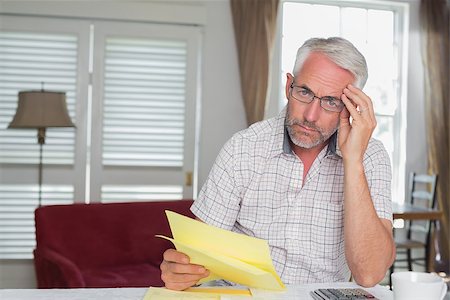 simsearch:400-07333928,k - Serious mature man sitting with home bills and calculator at table Stock Photo - Budget Royalty-Free & Subscription, Code: 400-07344635