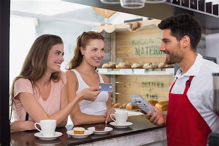 Smiling young friends with woman holding out credit card at the coffee shop Stock Photo - Budget Royalty-Free & Subscription, Code: 400-07345146