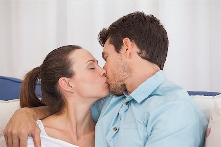 simsearch:400-07346120,k - Side view of a loving young couple kissing on couch at home Foto de stock - Super Valor sin royalties y Suscripción, Código: 400-07346082