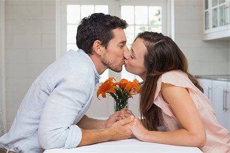 simsearch:400-07346120,k - Side view of a loving young couple kissing in the kitchen at home Foto de stock - Super Valor sin royalties y Suscripción, Código: 400-07346162