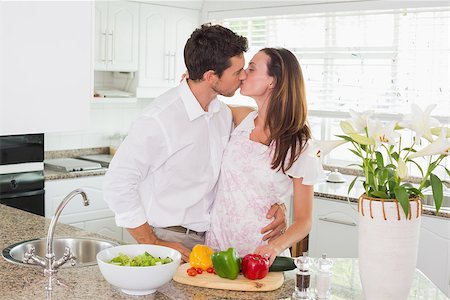 simsearch:400-07346120,k - Loving young couple kissing in the kitchen at home Foto de stock - Super Valor sin royalties y Suscripción, Código: 400-07346188
