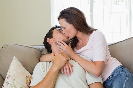 simsearch:400-07346120,k - Loving relaxed young couple kissing in the living room at home Foto de stock - Super Valor sin royalties y Suscripción, Código: 400-07346251