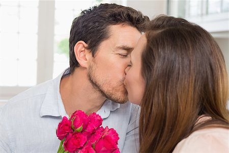 simsearch:400-07346120,k - Close-up of a loving young couple kissing with flowers in hand at home Foto de stock - Super Valor sin royalties y Suscripción, Código: 400-07346387