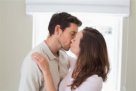 simsearch:400-07346120,k - Side view of a loving young couple kissing at home Foto de stock - Super Valor sin royalties y Suscripción, Código: 400-07346472