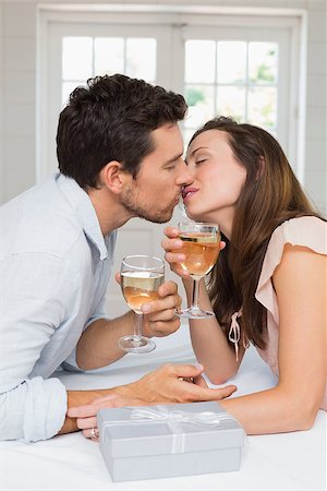 simsearch:400-07346120,k - Side view of a loving young couple kissing with wine glasses at home Foto de stock - Super Valor sin royalties y Suscripción, Código: 400-07346494