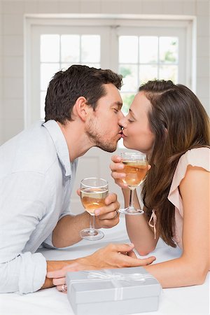 simsearch:400-07346120,k - Side view of a loving young couple kissing with wine glasses at home Foto de stock - Super Valor sin royalties y Suscripción, Código: 400-07346504