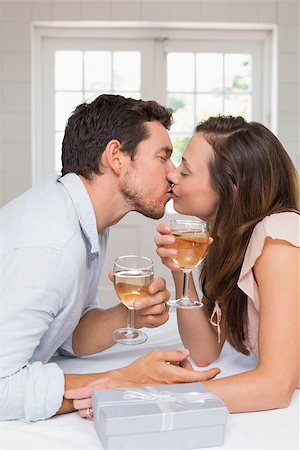 simsearch:400-07346120,k - Side view of a loving young couple kissing with wine glasses at home Foto de stock - Super Valor sin royalties y Suscripción, Código: 400-07346506