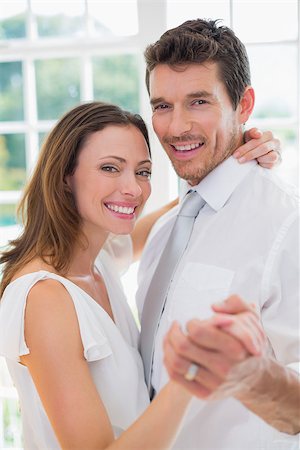 Portrait of a happy loving young couple dancing at home Stock Photo - Budget Royalty-Free & Subscription, Code: 400-07346748