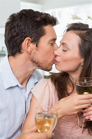 simsearch:400-07346120,k - Close-up of a loving young couple with wine glasses kissing at home Foto de stock - Super Valor sin royalties y Suscripción, Código: 400-07347119