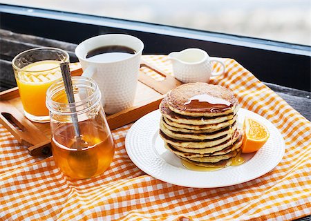 simsearch:400-07917638,k - Breakfast with pancakes, coffee, honey and juice on table at the window Stock Photo - Budget Royalty-Free & Subscription, Code: 400-07348144
