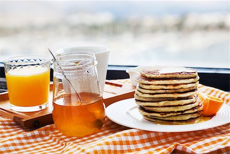 Breakfast with pancakes, coffee, honey and juice on table at the window Stockbilder - Microstock & Abonnement, Bildnummer: 400-07348145