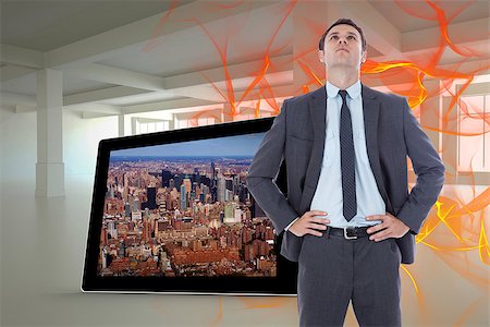 Serious businessman with hands on hips against abstract design in orange Stock Photo - Budget Royalty-Free & Subscription, Code: 400-07340062