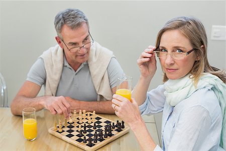 Portrait of a couple playing chess while having orange juice at home Stock Photo - Budget Royalty-Free & Subscription, Code: 400-07340552