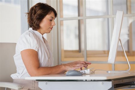 simsearch:400-07272682,k - Side view of a concentrated young businesswoman using computer at office desk Stockbilder - Microstock & Abonnement, Bildnummer: 400-07340598