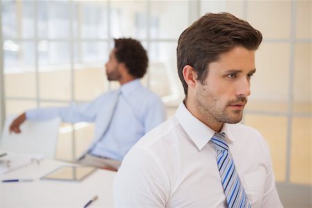 simsearch:400-04167566,k - Close-up side view of a serious businessman with colleagues in background at the office Stockbilder - Microstock & Abonnement, Bildnummer: 400-07340695