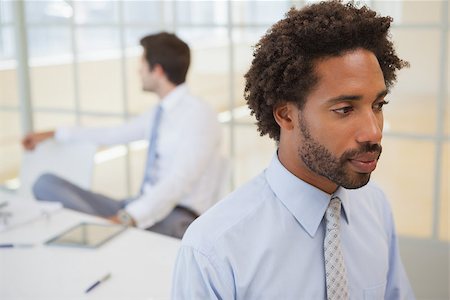 simsearch:400-04167566,k - Close-up side view of a serious businessman with colleagues in background at the office Stockbilder - Microstock & Abonnement, Bildnummer: 400-07340693