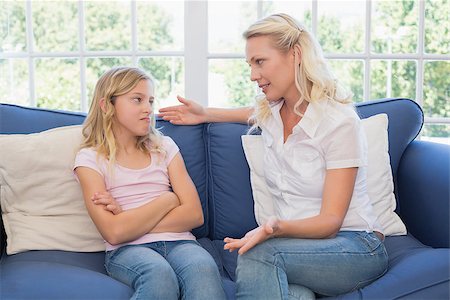 Woman explaining little girl while sitting on sofa at home Stock Photo - Budget Royalty-Free & Subscription, Code: 400-07341742
