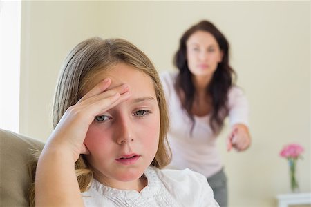 Disappointment girl with mother scolding her in background at home Stock Photo - Budget Royalty-Free & Subscription, Code: 400-07341935