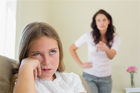 parent scolding kids - Bored girl with mother scolding her in background at home Stock Photo - Budget Royalty-Free & Subscription, Code: 400-07341937