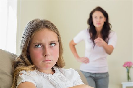 Angry little girl with mother scolding her in background at home Stock Photo - Budget Royalty-Free & Subscription, Code: 400-07341943