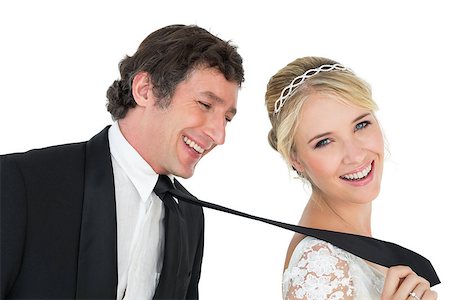 Portrait of attractive bride pulling tie of groom over white background Stock Photo - Budget Royalty-Free & Subscription, Code: 400-07342365