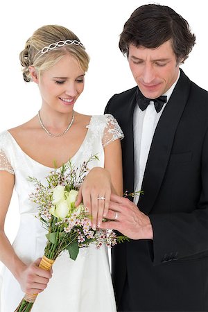simsearch:400-04950359,k - Newly wed couple with flower bouquet looking at wedding rings over white background Stock Photo - Budget Royalty-Free & Subscription, Code: 400-07342440