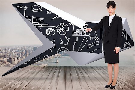 Focused businesswoman pointing against city scene in a room Stock Photo - Budget Royalty-Free & Subscription, Code: 400-07342778