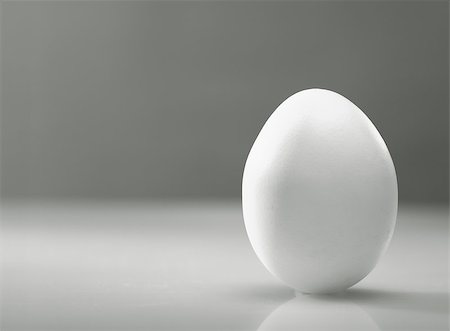 egg capsule - Simple as... White egg over desk with reflection and shadow Stock Photo - Budget Royalty-Free & Subscription, Code: 400-07404866