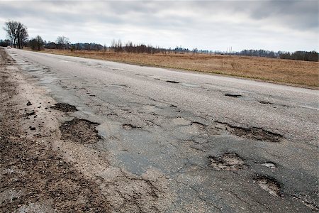 Badly damaged country asphalt road after winter Foto de stock - Royalty-Free Super Valor e Assinatura, Número: 400-07405551