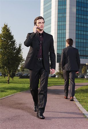 Businessman walking near office with mobie phone Foto de stock - Super Valor sin royalties y Suscripción, Código: 400-07406431