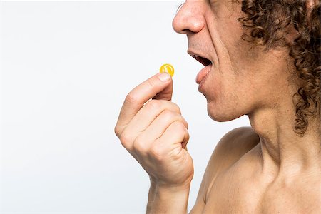 Cropped shot of bare chested mediterranean man taking colourful pill Stock Photo - Budget Royalty-Free & Subscription, Code: 400-07406650