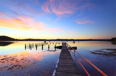 simsearch:400-07514503,k - Vivid and colourful sunset at mid tide, Yattalunga Australia.   Jetty wharf and harbour pool, boats and yachts moored on the evening waters at Yattalunga, on the NSW Central Coast, Australia. Stock Photo - Budget Royalty-Free & Subscription, Code: 400-07407206