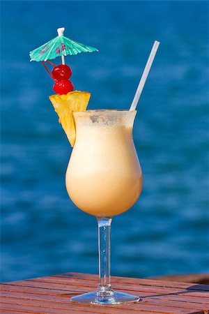 pina colada served on the beach garnished with fresh pineapple and cherries Foto de stock - Super Valor sin royalties y Suscripción, Código: 400-07407445