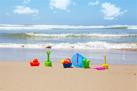 Plastic beach toys on beach with sea and clouds in background Stock Photo - Budget Royalty-Free & Subscription, Code: 400-07409580