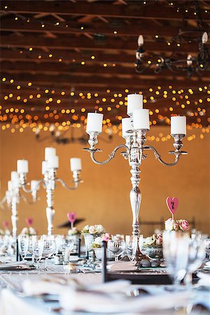 Candelabra with candles on decorated tables at a wedding reception; selective focus on candelabra Stock Photo - Budget Royalty-Free & Subscription, Code: 400-07409590