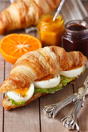 simsearch:400-07414812,k - Fresh croissant with boiled egg and salad and salad, sweet jam and orange fruit for breakfast on a wooden board close-up. Foto de stock - Super Valor sin royalties y Suscripción, Código: 400-07414866