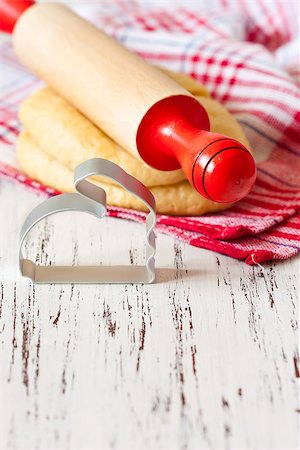 simsearch:400-06693299,k - Cooking Easter biscuits. Fresh sweet dough, wooden rolling pin and funny bunny cookie cutter on a white wooden board with place for text. Foto de stock - Royalty-Free Super Valor e Assinatura, Número: 400-07414868