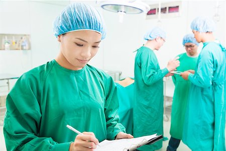 simsearch:400-07412766,k - woman Surgeons writing medical record with teams Foto de stock - Super Valor sin royalties y Suscripción, Código: 400-07418304