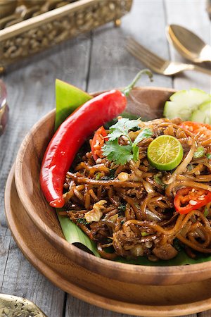 fried chicken with banana - Mee goreng mamak or mi goreng, Indonesian and Malaysian cuisine, spicy fried noodles with wooden dining table setting. Fresh hot with steamed smoke. Stock Photo - Budget Royalty-Free & Subscription, Code: 400-07418419