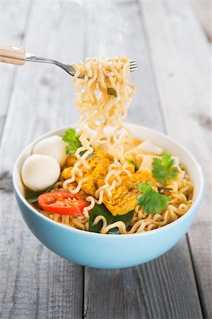 simsearch:400-05297094,k - Spicy curry instant noodles holding with fork. Asian cuisine, ready to serve on wooden dining table setting. Fresh hot with steamed smoke. Fotografie stock - Microstock e Abbonamento, Codice: 400-07418433
