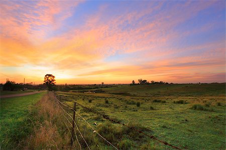 dawn red sky - Sunrise throws a warm light over the countryside hills, paddocks and farm sheds.   Orchard Hills, Australia Stock Photo - Budget Royalty-Free & Subscription, Code: 400-07418605