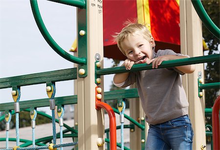simsearch:400-04707386,k - Happy little boy having fun on playground equipment and then something attracts his attention. Photographie de stock - Aubaine LD & Abonnement, Code: 400-07418721