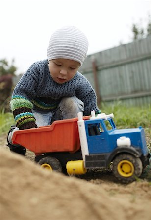 rural family truck - Little boy playing with toy truck rolling it on the sand. Having fun outdoors. Stock Photo - Budget Royalty-Free & Subscription, Code: 400-07418722