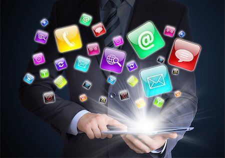 simsearch:400-07446368,k - Man in suit holding tablet pc and application icons in hand. The concept of software Foto de stock - Super Valor sin royalties y Suscripción, Código: 400-07419673